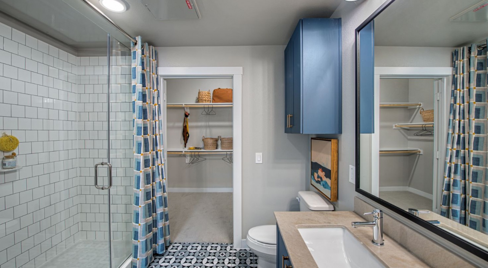a bathroom with blue cabinets and a shower stall at The Ramble and Rose
