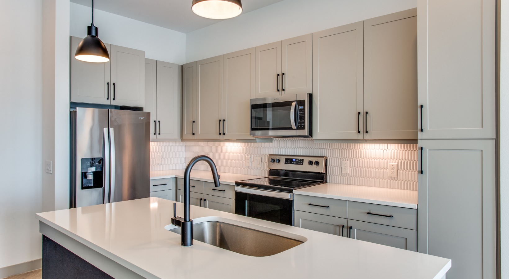 a kitchen with stainless steel appliances and white counter tops at The Ramble and Rose