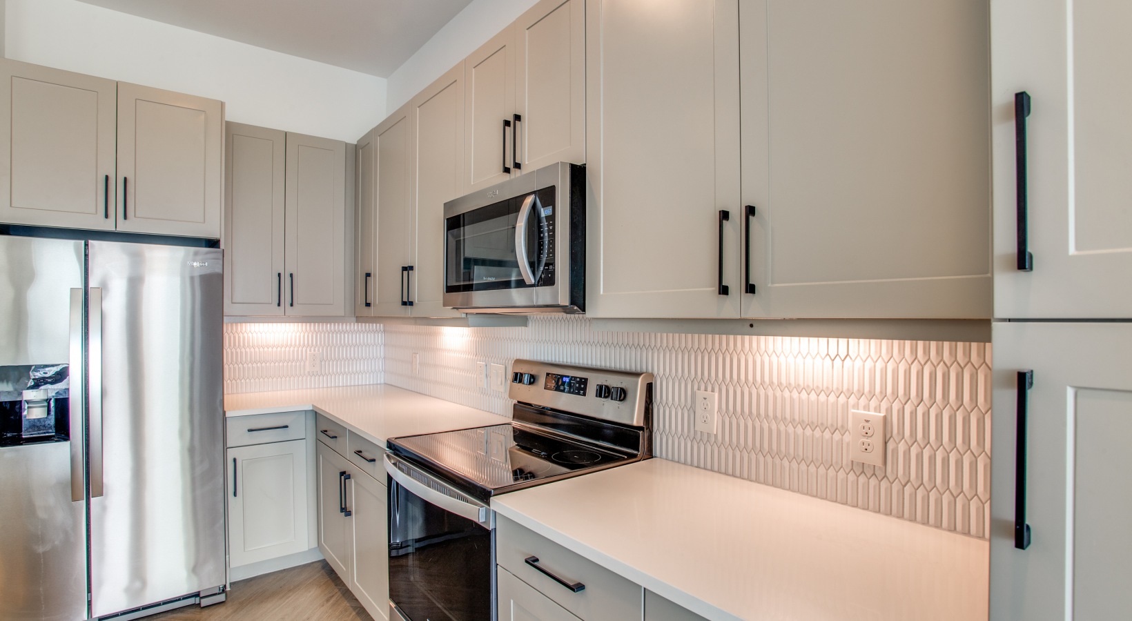 a kitchen with stainless steel appliances and white cabinets at The Ramble and Rose