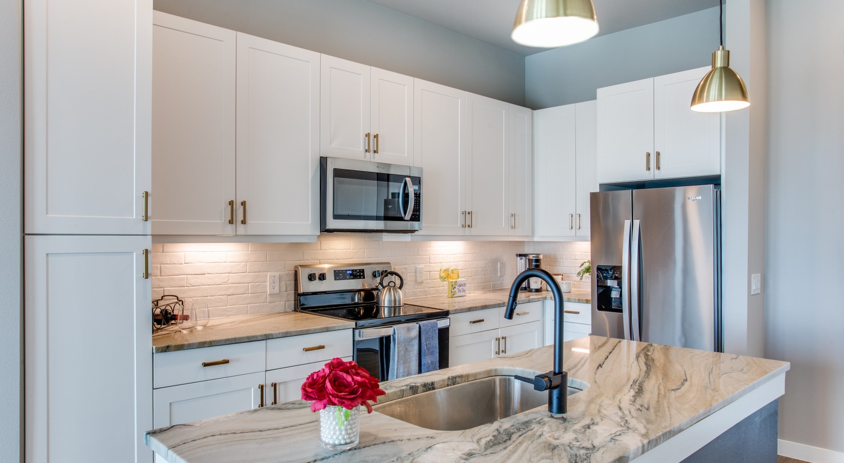 a kitchen with white cabinets and stainless steel appliances at The Ramble and Rose