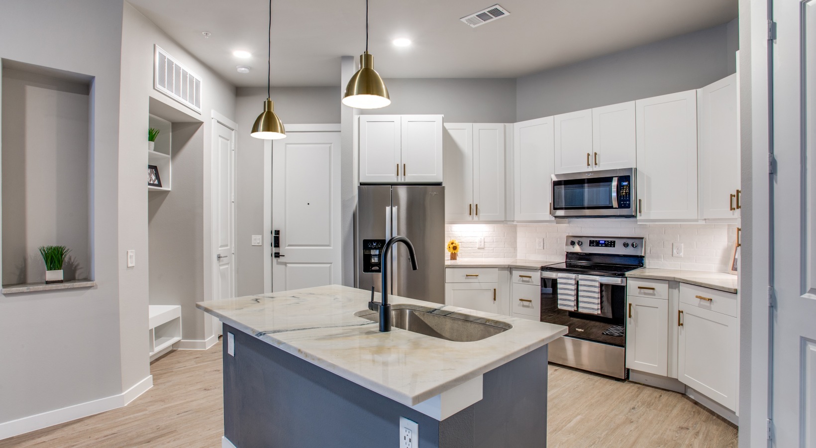 a kitchen with white cabinets and stainless steel appliances at The Ramble and Rose