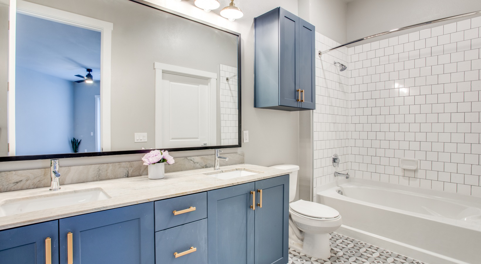 a bathroom with blue cabinets and a white tub at The Ramble and Rose