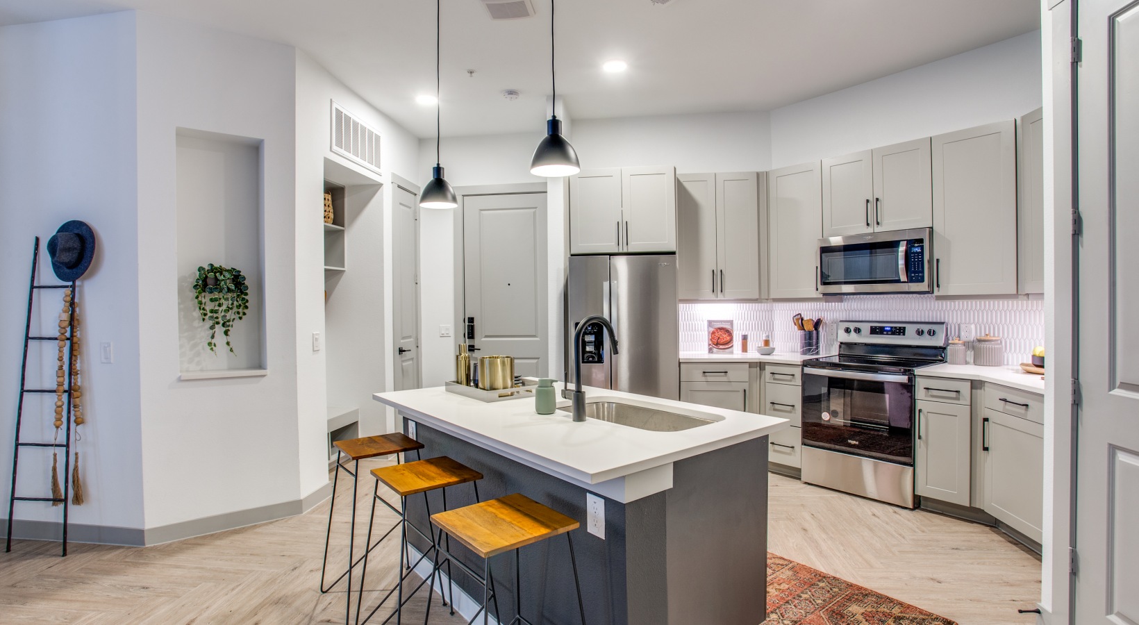 a kitchen with stainless steel appliances and bar stools at The Ramble and Rose