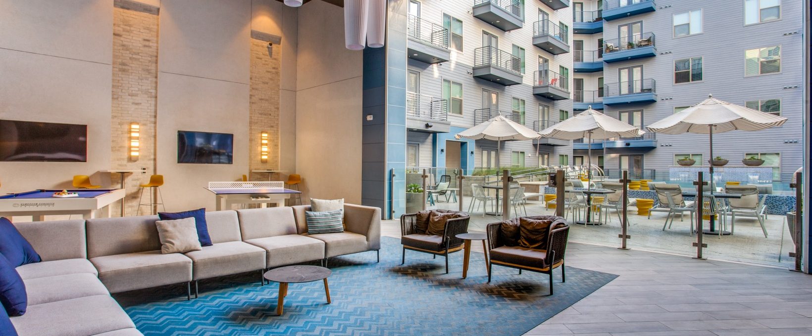 the lobby of an apartment building with blue carpeting at The Ramble and Rose