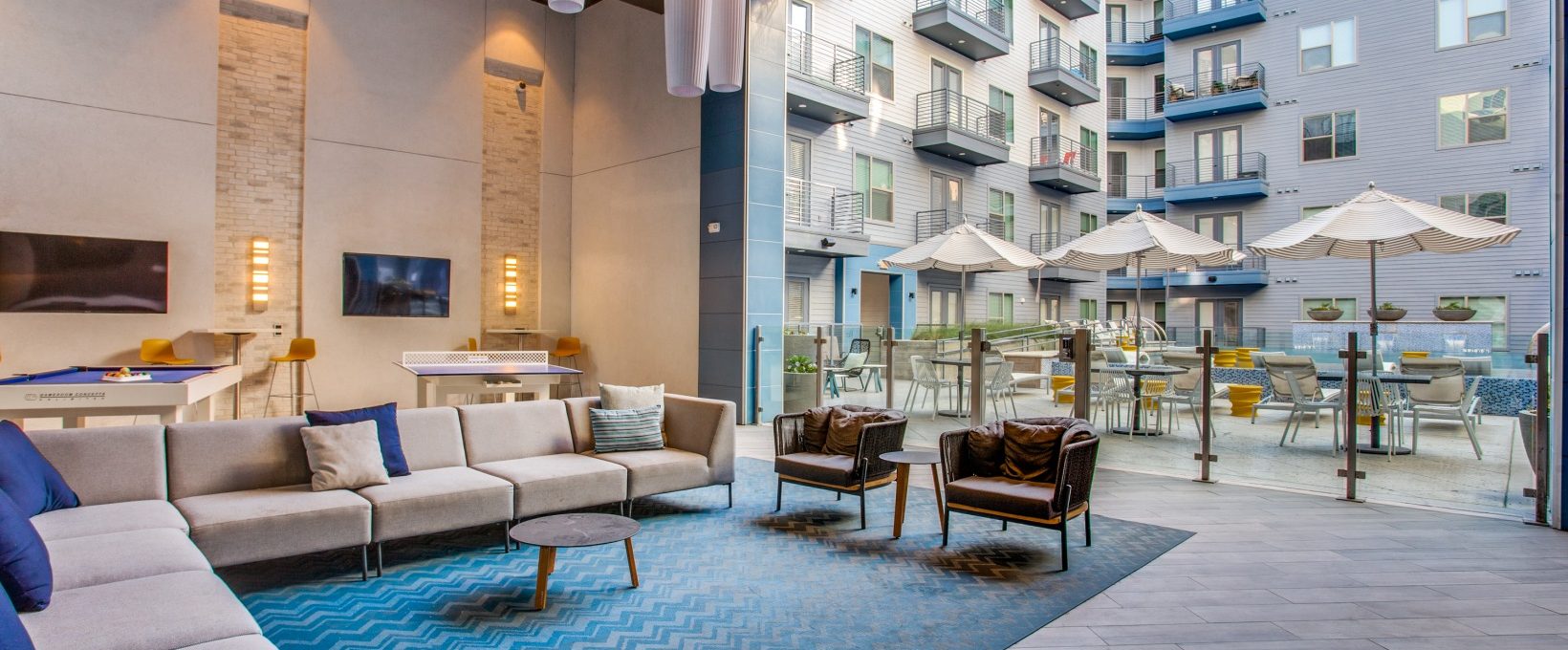 the lobby of an apartment building with blue carpeting at The Ramble and Rose
