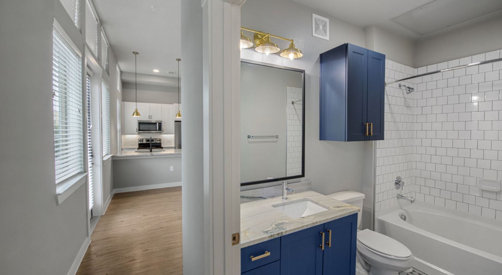a bathroom with blue cabinets and white tile at The Ramble and Rose