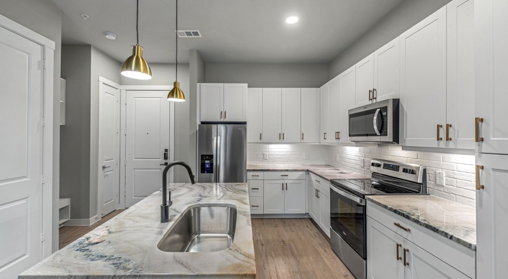 a kitchen with stainless steel appliances and marble counter tops at The Ramble and Rose