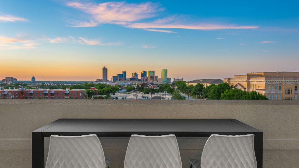 a table and chairs on a balcony overlooking a city at The Ramble and Rose