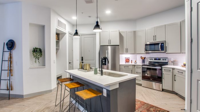 a kitchen with stainless steel appliances and bar stools at The Ramble and Rose