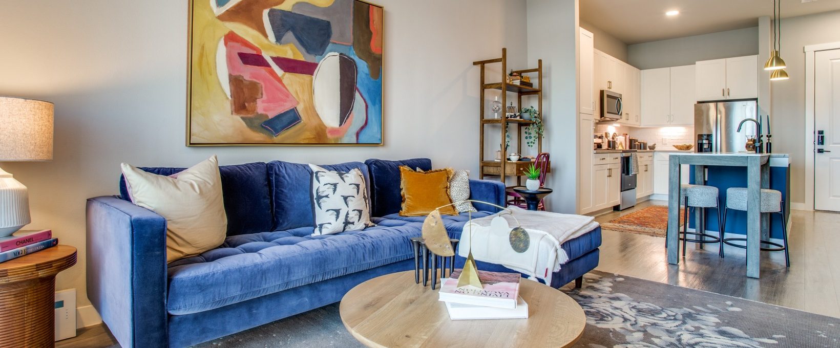 a living room with blue couch, blue chairs and a blue painting at The Ramble and Rose