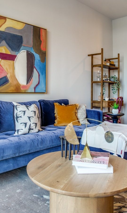 a living room with blue couch, blue chairs and a blue painting at The Ramble and Rose